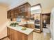 Cozy kitchen featuring wooden cabinets, stainless steel appliances, and unique patterned flooring at 4000 S Dahlia St, Cherry Hills Village, CO 80113