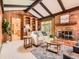 Cozy living room with a brick fireplace, wood paneled walls, and exposed beam ceiling at 4000 S Dahlia St, Cherry Hills Village, CO 80113