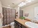 Clean bathroom features a vanity with a sink, a large mirror, and a shower-tub combo at 353 Zuniga St, Brighton, CO 80601