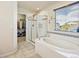 Bright bathroom has a soaking tub, a glass-enclosed shower, and a walk-in closet at 353 Zuniga St, Brighton, CO 80601