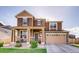 Charming two-story home featuring stone accents, a covered porch, and a two-car garage at 353 Zuniga St, Brighton, CO 80601