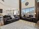 Open-concept living room with high ceilings, large windows, and comfortable leather sofas at 353 Zuniga St, Brighton, CO 80601