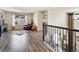 Upstairs loft space with wood floors and railing overlooking the living area below at 353 Zuniga St, Brighton, CO 80601