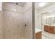 Shower and vanity in a bathroom with large neutral-toned tile and wood vanity at 3915 E Jamison Pl, Centennial, CO 80122