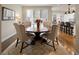 Cozy dining area with a large round table, upholstered chairs, hardwood floors, and bright windows at 216 N Monroe St, Denver, CO 80206