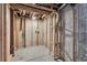 Unfinished basement featuring wooden framing, concrete walls, and exposed ceiling elements, offering renovation potential at 10836 W Evans Ave # 32, Lakewood, CO 80227