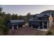 Beautiful dark modern home with a detached garage in a serene setting surrounded by lush greenery and distant mountains at 30796 Burland Rd, Golden, CO 80403