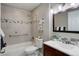 Well-lit bathroom with a shower, a gray vanity and a dark framed mirror at 3550 S Harlan St # 259, Denver, CO 80235