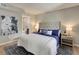 Comfortable bedroom with a tufted headboard, a gray rug and an ensuite bathroom at 3550 S Harlan St # 259, Denver, CO 80235