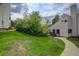 Exterior shot of home with grassy lawn, mature trees, and sidewalk to the entrance at 3550 S Harlan St # 259, Denver, CO 80235