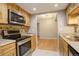 Kitchen featuring stainless steel appliances, wood cabinets, and a view of the adjacent dining area at 3550 S Harlan St # 259, Denver, CO 80235