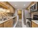 Bright kitchen features stainless steel appliances, light wood cabinets, tile backsplash and a laundry room access at 3550 S Harlan St # 259, Denver, CO 80235