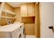 Convenient laundry room with washer, dryer, shelving, and overhead cabinets for optimal storage at 3550 S Harlan St # 259, Denver, CO 80235