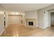 Open living room featuring a fireplace, wood floors, and access to other rooms in the house at 3550 S Harlan St # 259, Denver, CO 80235