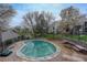 Community pool area with mature trees, fencing, and seating at 3550 S Harlan St # 259, Denver, CO 80235