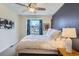 Bright bedroom with a ceiling fan, a navy accent wall, large window and a comfortable-looking bed at 2163 S Grant St, Denver, CO 80210