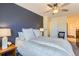 A comfortable bedroom features a navy accent wall and a ceiling fan and an adjacent hallway at 2163 S Grant St, Denver, CO 80210