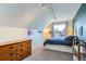 Attic bedroom featuring a sloped ceiling, dresser, a window and a small bed with blue linens at 2163 S Grant St, Denver, CO 80210