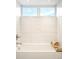 Modern bathroom showcasing white marble tiled walls, with a bathtub and window for natural light at 2659 S Cherokee St, Denver, CO 80223