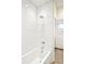 Clean white tiled bathtub and shower with chrome fixtures in a modern bathroom at 2659 S Cherokee St, Denver, CO 80223