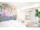 Bright bedroom featuring a walk-in closet, jungle themed wall art and a plant at 2659 S Cherokee St, Denver, CO 80223