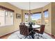 Bright dining area features a modern light fixture, three large windows and a round table with leather chairs at 6542 S Tempe St, Aurora, CO 80016