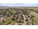 Wide aerial view of a neighborhood featuring homes nestled among mature trees, with a highway in the distance at 8072 Windwood Way, Parker, CO 80134