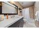 Modern bathroom features a tub, shower and vanity with a dark cabinet and a white countertop at 8072 Windwood Way, Parker, CO 80134