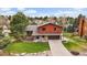 Beautiful two-story home with a lush green lawn, mature trees, and an attached two car garage and long driveway at 8072 Windwood Way, Parker, CO 80134