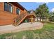 An exterior shot of a wood-sided home with a staircase leading to a deck and backyard at 8072 Windwood Way, Parker, CO 80134