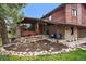 Charming brick and wood exterior with a well-manicured rock garden and inviting covered porch with blue seating at 8072 Windwood Way, Parker, CO 80134