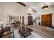 Bright and spacious living room with a high ceiling, wood floors, and an open view of the dining area and staircase at 8072 Windwood Way, Parker, CO 80134