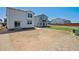 View of the back of a white two-story home with a large yard with room for custom landscaping at 2169 Flower Blossom Ave, Brighton, CO 80601
