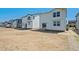Backyard view of multiple new construction homes with sliding glass doors and graded, customizable backyards at 2169 Flower Blossom Ave, Brighton, CO 80601