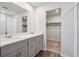 Bathroom featuring double sinks, quartz countertops, gray cabinets, and a walk-in closet at 2169 Flower Blossom Ave, Brighton, CO 80601