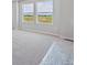 Bright bedroom with a view, neutral walls, carpeted floors, and natural light from two windows at 2169 Flower Blossom Ave, Brighton, CO 80601