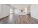 An open living room area with hardwood floors, a modern kitchen, and natural light at 2169 Flower Blossom Ave, Brighton, CO 80601