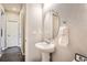 Cozy half bathroom featuring a pedestal sink, oval mirror, and decorative touches at 6777 S Old Hammer Ct, Aurora, CO 80016