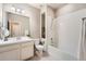 Well-lit bathroom featuring white cabinets, tile surround, large mirror and shower-tub combination at 6777 S Old Hammer Ct, Aurora, CO 80016