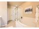Bright bathroom featuring a large soaking tub, glass-enclosed shower, and modern fixtures at 6777 S Old Hammer Ct, Aurora, CO 80016