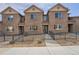 Charming townhome with brick facade, fenced front yard, and well-maintained landscaping at 6777 S Old Hammer Ct, Aurora, CO 80016