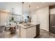Open kitchen with stainless appliances, a breakfast bar, and seamless flow to dining and living areas at 6777 S Old Hammer Ct, Aurora, CO 80016