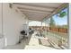Covered back patio area with grill, bar seating, and wooden railing at 3732 S Halifax St, Aurora, CO 80013