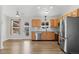 Updated kitchen with stainless steel appliances, light wood cabinets, and open floor plan to the living room at 3732 S Halifax St, Aurora, CO 80013