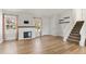 Inviting living room with wood floors, white walls, fireplace, two windows and staircase at 3732 S Halifax St, Aurora, CO 80013