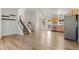 Bright living room with wood floors, white walls, stairs, and an open floor plan to the kitchen at 3732 S Halifax St, Aurora, CO 80013