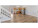 Bright living room with wood floors, white walls, stairs, and an open floor plan to the kitchen at 3732 S Halifax St, Aurora, CO 80013