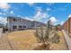 View of the home's back exterior, complemented by an expansive backyard with wood and vinyl fences at 5251 Truckee St, Denver, CO 80249