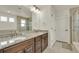 Bathroom featuring dual sinks, granite countertops, and a glass-enclosed shower at 5251 Truckee St, Denver, CO 80249