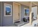 Close up of the front door with a storm door and a cozy chair set on the covered front porch at 5251 Truckee St, Denver, CO 80249